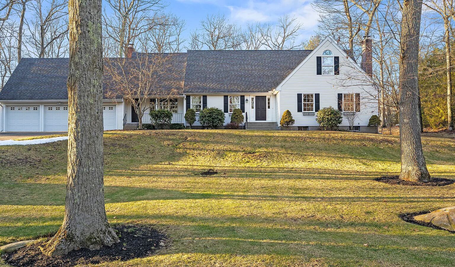 Classic white cape with black shutters on a tree-lined Glastonbury CT lot