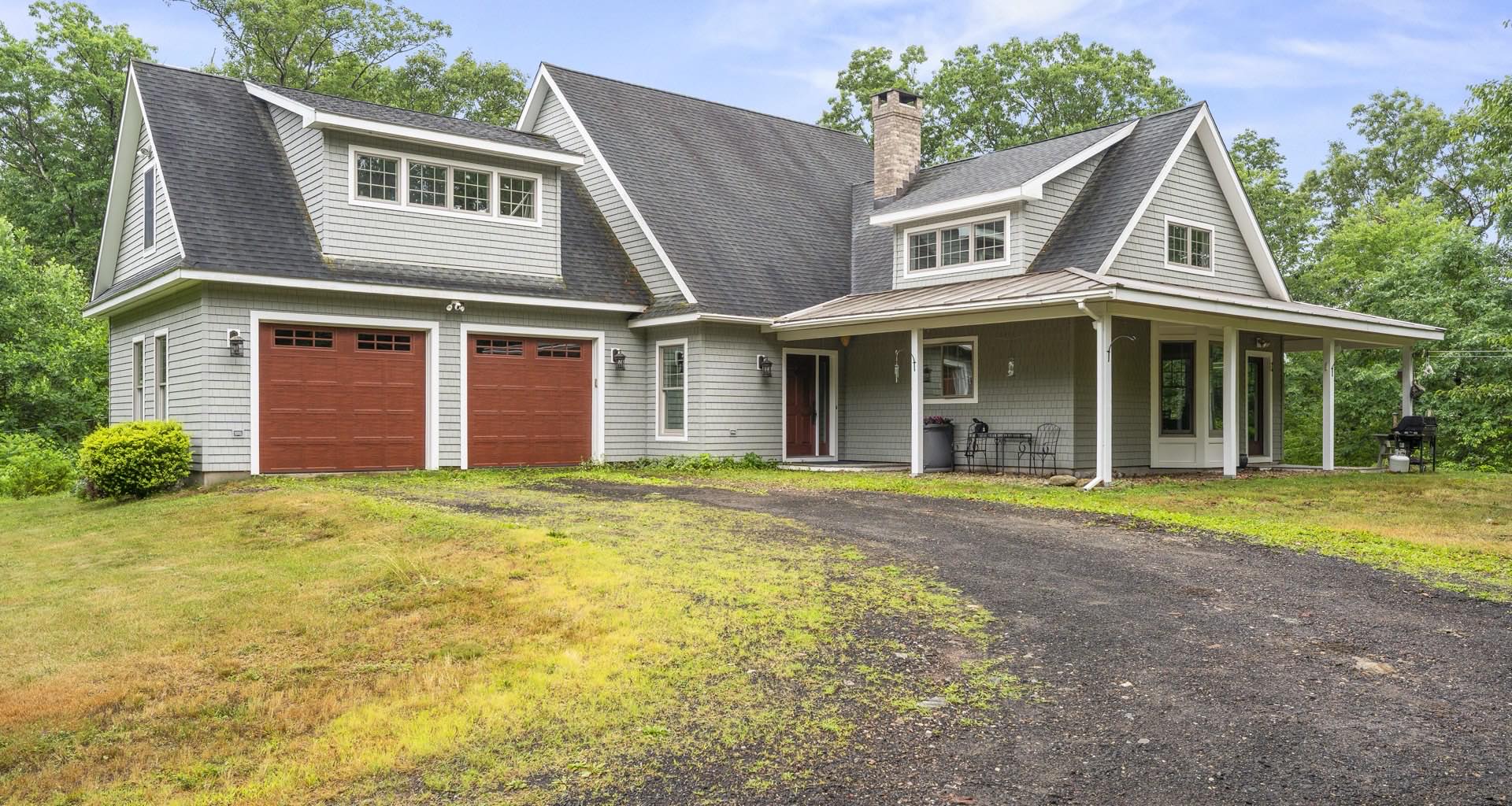 Shingle-style Connecticut home with red garage doors listed by the Feery Family Team